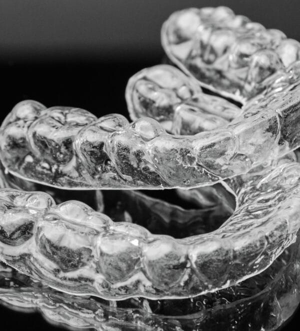 Invisalign in Oakland, NJ, on a black background.
