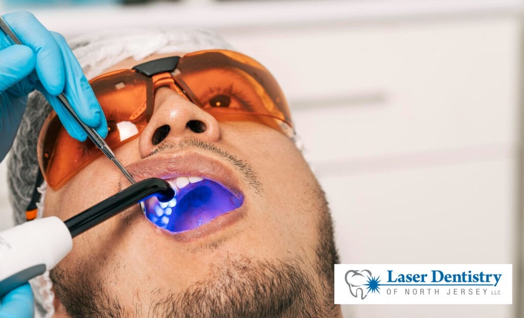 Dentist whitening a patient's teeth with laser in a dental clinic